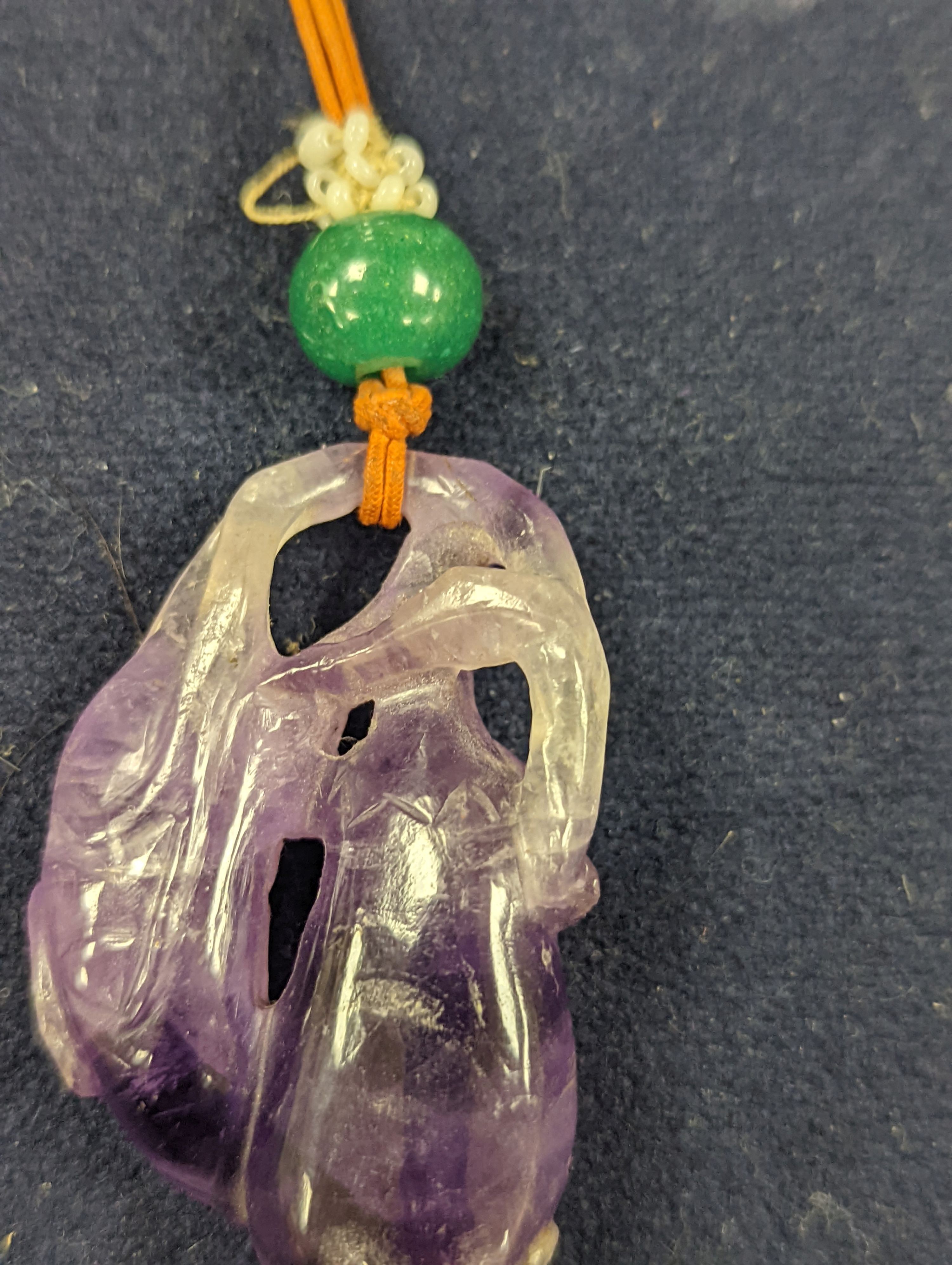 A 19th century Chinese carved amethyst pendant, 5cm on an ornate cord